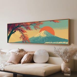 Könnte beinhalten: Ein horizontales, rechteckiges Wandbild mit einem schneebedeckten Berggipfel in Blaugrün und Weiß vor einer großen, einfarbigen orangefarbenen Sonne. Ein dunkler Baum mit leuchtend roten Blättern hängt über der Szene, gerahmt in hellem Holz.