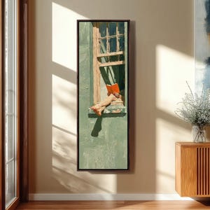 Puede incluir: Una impresión de arte mural vertical enmarcada que representa a una persona sentada en el alféizar de una ventana leyendo un libro naranja abierto. La escena presenta una pared verde salvia texturizada, un marco de madera y sombras marcadas.