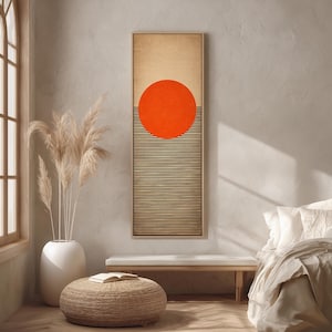 Könnte beinhalten: Ein gerahmter abstrakter Wandkunstdruck. Das Kunstwerk zeigt einen großen orangefarbenen Kreis über einer Reihe von schwarzen und goldenen horizontalen Linien. Der obere Teil des Drucks ist hellbraun. Das Kunstwerk wird in einem hellen Raum ausgestellt.