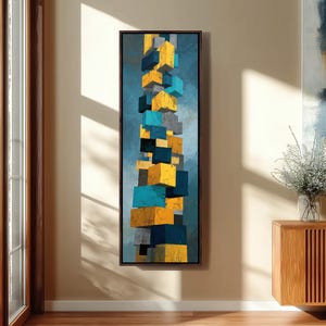 Puede incluir: Impresión artística abstracta con una composición vertical de cubos tridimensionales apilados. Los cubos están pintados en tonos de amarillo, azul, gris y azul marino sobre un fondo azul texturizado, todo dentro de un marco marrón oscuro.