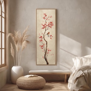 May include: A framed vertical art print featuring a stylized tree with red blossoms and a small bird perched on a branch. The artwork has a neutral background and a wooden frame, suitable for home decor.