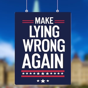 Może przedstawiać: Granatowy znak z napisem "MAKE LYING WRONG AGAIN" w kolorze białym. Znak ma czerwone poziome linie i gwiazdy u góry i u dołu. Tło to rozmyty obraz budynku i nieba.