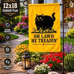 May include: A yellow 12x18 inch garden flag with a black cat illustration stepping on a snake. The text "OH LAWD HE TREADIN'" is below the cat. The flag is weather and fade resistant, made of premium durable fabric, and double-sided.