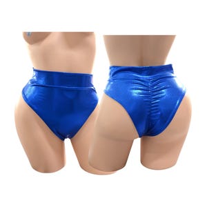 Può includere: Un paio di pantaloncini metallizzati blu a vita alta. I pantaloncini sono esposti su un manichino, mostrando le viste anteriore e posteriore. Il tessuto ha una qualità lucida e riflettente.