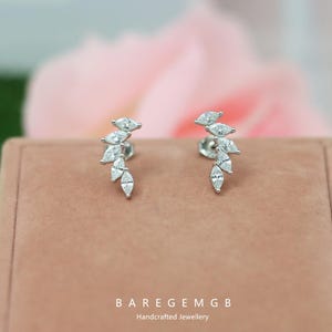 Puede incluir: Pendientes de plata con diseño de cascada de gemas claras con corte marquesa. Se exhiben sobre una superficie rosa. El texto "BAREGEMGB Handcrafted Jewellery" es visible en la parte inferior.