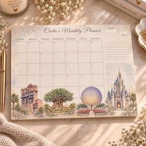 May include: A rectangular monthly planner notepad titled Carla's Monthly Planner with a grid for days of the week. The bottom features illustrations of the Hollywood Tower Hotel, the Tree of Life, Spaceship Earth, and a castle.