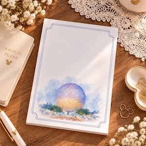 May include: A rectangular notepad featuring a blue line border and a watercolor illustration of a large geodesic sphere structure surrounded by trees. The paper is white with a smooth finish, designed for writing notes or lists in a professional setting.
