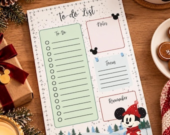 May include: A rectangular paper to-do list notepad featuring a winter theme with pine trees and a cartoon mouse wearing a red winter hat and coat. The layout includes sections labelled To-Do, Notes, Focus, and Remember with black text and icons.