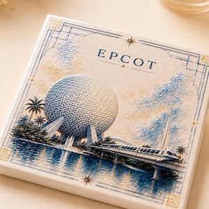 May include: A square ceramic tile featuring a raised, textured illustration of the Epcot geodesic sphere and a monorail train. The design includes blue and gold accents, palm trees, water reflections, and the text EPCOT in a serif font.