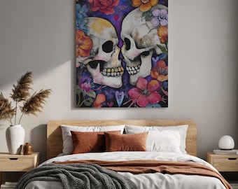 May include: A canvas print featuring two skulls with colorful floral accents. The skulls are depicted in a watercolor style, surrounded by roses, and other flowers in shades of pink, orange, and blue. The artwork is displayed above a bed with a wooden frame.