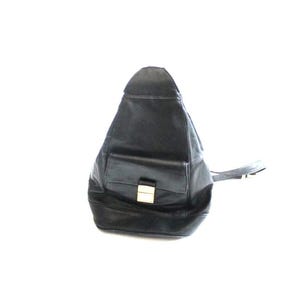 May include: A black leather sling backpack with a teardrop shape, featuring a front flap pocket secured by a rectangular gold-tone metal clasp. The bag has a single adjustable strap extending to the side and a smooth, dark finish throughout.