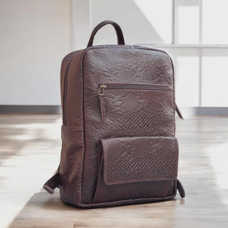 Side View: "Side view highlighting the adjustable leather shoulder straps and the compact design of the full-grain leather rucksack.