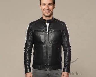 May include: Black leather jacket with a zip-up front, two chest pockets, and a stand-up collar. The jacket has a quilted design on the shoulders and is worn with gray pants. The jacket is a classic style.