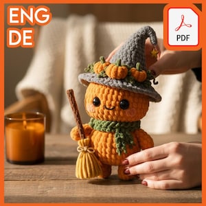 Könnte beinhalten: Eine gehäkelte Kürbispuppe mit einem grauen Hexenhut, der mit kleinen orangefarbenen Kürbissen und einem grünen Schal verziert ist. Die Puppe hält einen kleinen Besen. Das Bild enthält auch eine Kerze und den Text "ENG DE" und ein PDF-Symbol.
