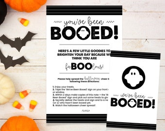 May include: Black and white printable Halloween "Booed" sign with a ghost graphic and instructions for a fun Halloween tradition. The sign says "You've Been Booed!" and "We've Been Booed!"