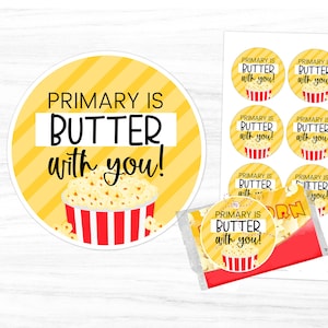 May include: A set of printable round stickers with the text "Primary is Butter with you!" and a cartoon image of a red and white striped popcorn bucket with yellow popcorn. The stickers are designed for teachers to give to students as a fun treat.