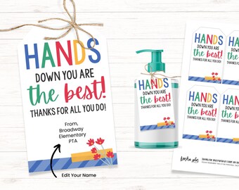 Könnte beinhalten: Ein druckbarer Geschenkanhänger für Lehrer mit dem Text "Hände runter, du bist der Beste! Danke für alles, was du tust!" in bunten Buchstaben. Der Anhänger hat einen blau-gelb gestreiften Hintergrund mit einem roten Blumendesign. Der Text "Von der Broadway Elementary PTA" befindet sich unter dem Haupttext. Der Anhänger ist dazu gedacht, an eine Flasche Handdesinfektionsmittel angebracht zu werden.