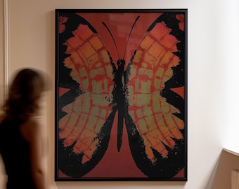 May include: A framed butterfly art print. The artwork features a large butterfly with black outlines and wings in shades of orange, red, and green against a red background. The print is displayed in a black frame.