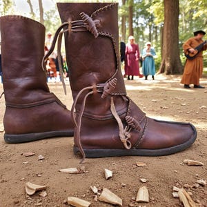 May include: A pair of brown leather boots with a medieval design. The boots have a mid-calf height, with decorative leather ties and stitching. The boots are on a dirt surface, with people in the background.