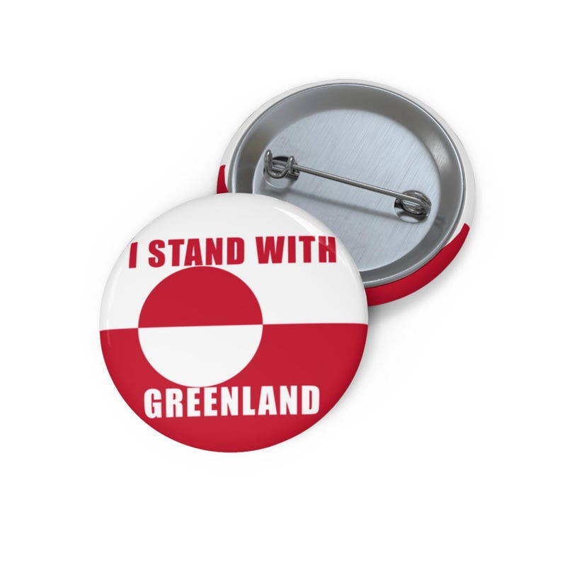 May include: Two round badges with a white and red design. The text "I STAND WITH GREENLAND" is printed on the front badge. The badge has a metal pin on the back.