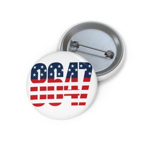 May include: A round pinback button featuring the numbers 0647 printed in a bold font. The top half of the numbers displays a blue background with white stars, while the bottom half features horizontal red and white stripes. A metal pin is visible.