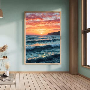 May include: A framed painting depicts a vibrant sunset over the ocean. The sky is filled with orange and pink hues, reflecting on the water. Waves crash, and a distant land mass is visible. The artwork is displayed in a room with light blue walls and wooden floors.
