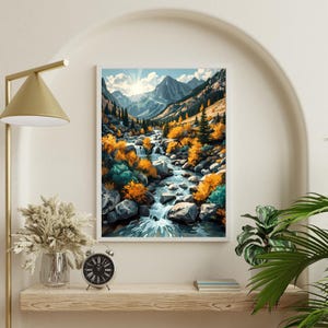 May include: A framed landscape art print depicts a mountain valley with a river flowing through it. The artwork features a vibrant color palette of blues, greens, and yellows, with a bright sun shining in the background. The print is displayed on a wooden shelf.