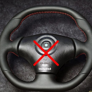 Op de afbeelding: Zwart stuurwiel met rode stiksels. Het wiel heeft een geperforeerde lederen grip en een middennaaf met een logo. De woorden "AIRBAG Niet inbegrepen" zijn zichtbaar.