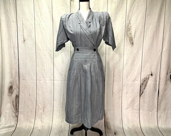 May include: A gray and white striped dress with a collared neckline and a button closure. The dress has a fitted bodice and a full skirt.