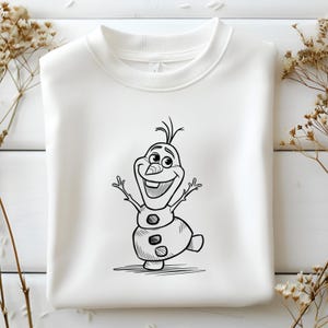 May include: White crew neck sweatshirt featuring a black and white cartoon illustration of Olaf, the snowman character. Olaf is smiling with his arms raised, and the design is centered on the front of the sweatshirt.