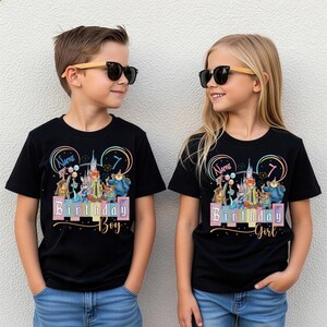Pu&ograve; includere: Due magliette nere con una grafica colorata di personaggi animati, la sagoma di un castello e il numero 7. Una maglietta riporta il testo Name e Birthday Boy, l'altra riporta il testo Name e Birthday Girl in colori pastello.