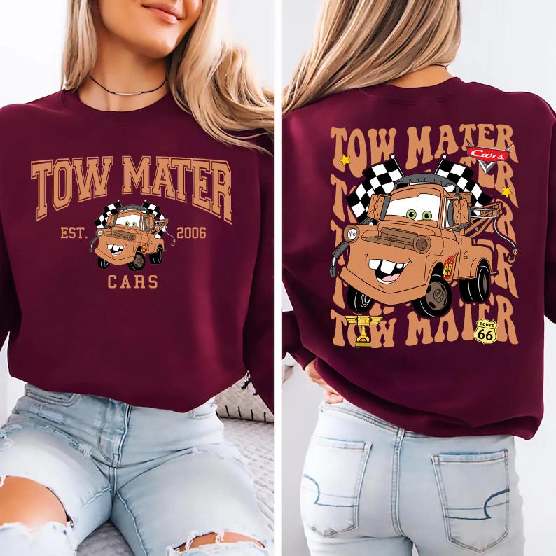 May include: Burgundy sweatshirt featuring a cartoon image of Tow Mater from the Cars movie. The front design includes the text "TOW MATER" above the character, with "EST. 2006" and "CARS" below. The back design repeats the character and text.