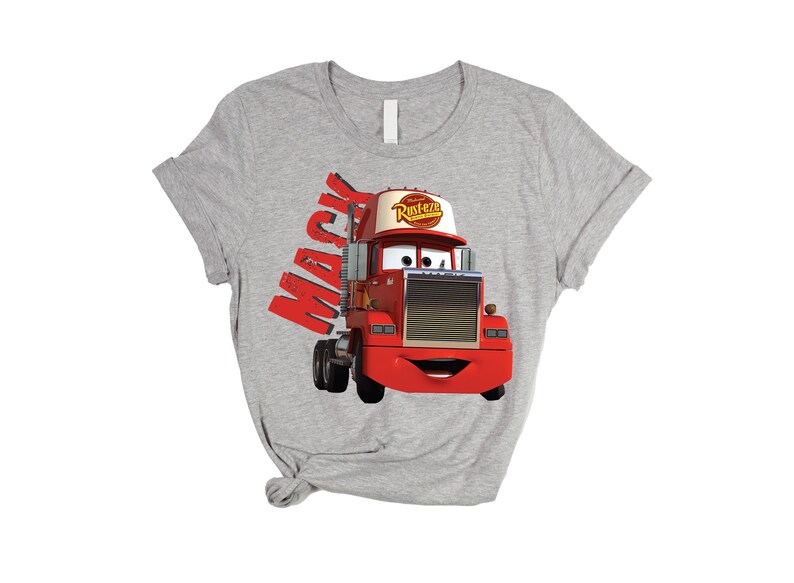 May include: A gray t-shirt featuring a cartoon image of Mack, the red semi-truck from the movie Cars. The word "Mack" is printed in red on the left side of the shirt. The truck has a white and red hat that says "Rusteze".