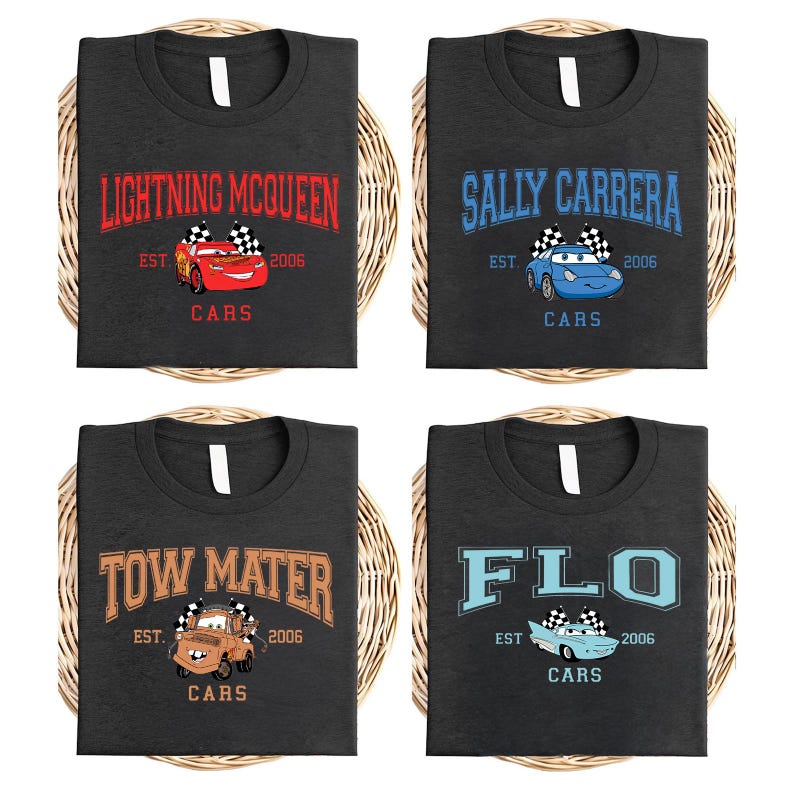 May include: Four dark gray t-shirts with different Cars movie character designs. Each shirt features a character name, a car graphic, the text "EST. 2006", and the word "CARS". The designs include Lightning McQueen, Sally Carrera, Tow Mater, and Flo.