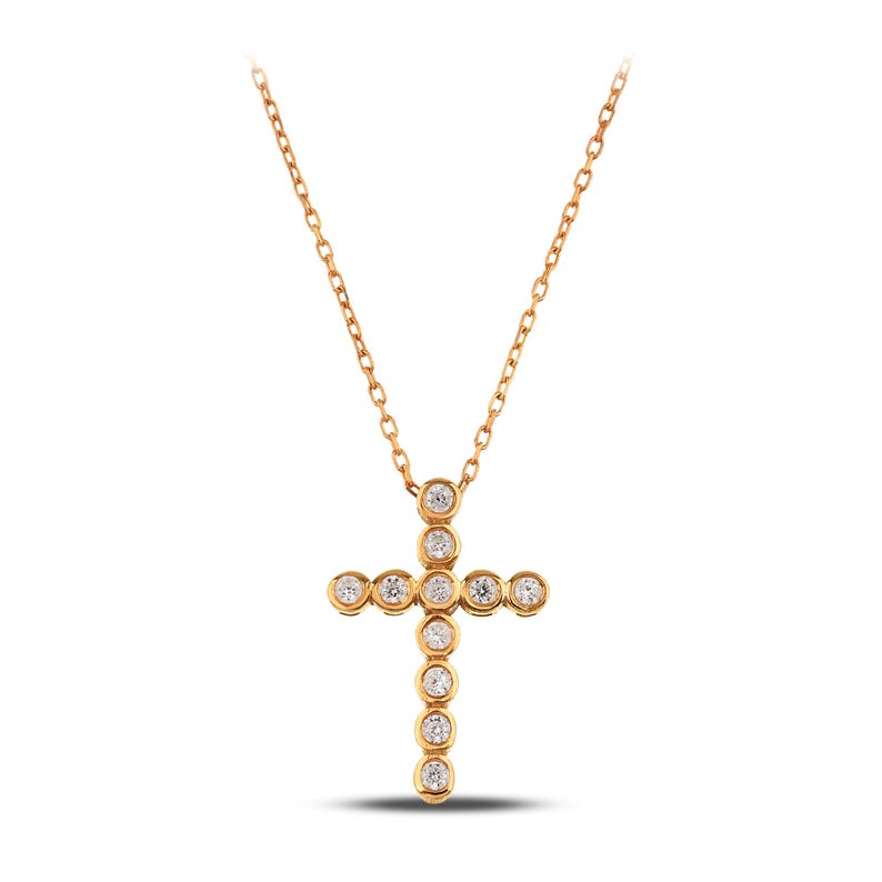K&ouml;nnte beinhalten: Eine goldfarbene Halskette mit einem Kreuzanh&auml;nger. Das Kreuz ist mit runden, klaren Edelsteinen verziert, die in einzelnen Fassungen gefasst sind. Die Kette und der Anh&auml;nger haben eine polierte Oberfl&auml;che, die einen funkelnden Effekt erzeugt. Die Halskette wird vor wei&szlig;em Hintergrund pr&auml;sentiert.