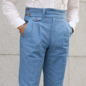 Pantalones Gurkha de cintura alta para hombre: pantalones azules a medida con pliegues y detalle de hebilla lateral.