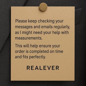 May include: A tan rectangular tag with the text "Please keep checking your messages and emails regularly, as I might need your help with measurements. This will help ensure your order is completed on time and fits perfectly. REALEVER." The tag is attached to a dark gray fabric with a gold-colored pin.