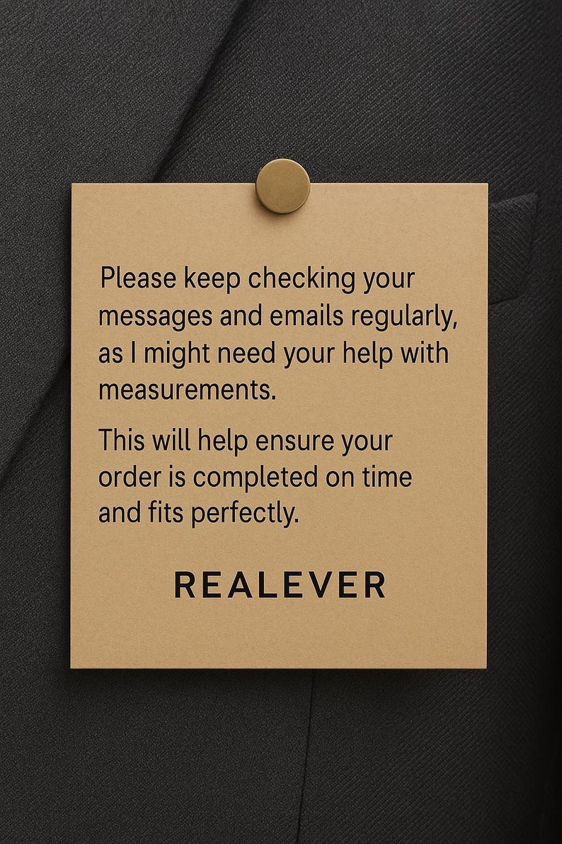 May include: A tan rectangular tag with the text "Please keep checking your messages and emails regularly, as I might need your help with measurements. This will help ensure your order is completed on time and fits perfectly. REALEVER." The tag is attached to a dark gray fabric with a gold-colored pin.