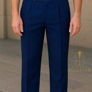 May include: Navy blue dress pants with a pleated front and a belt loop detail. The pants are tailored and have a classic design. The image also shows the logo "REALEVER".