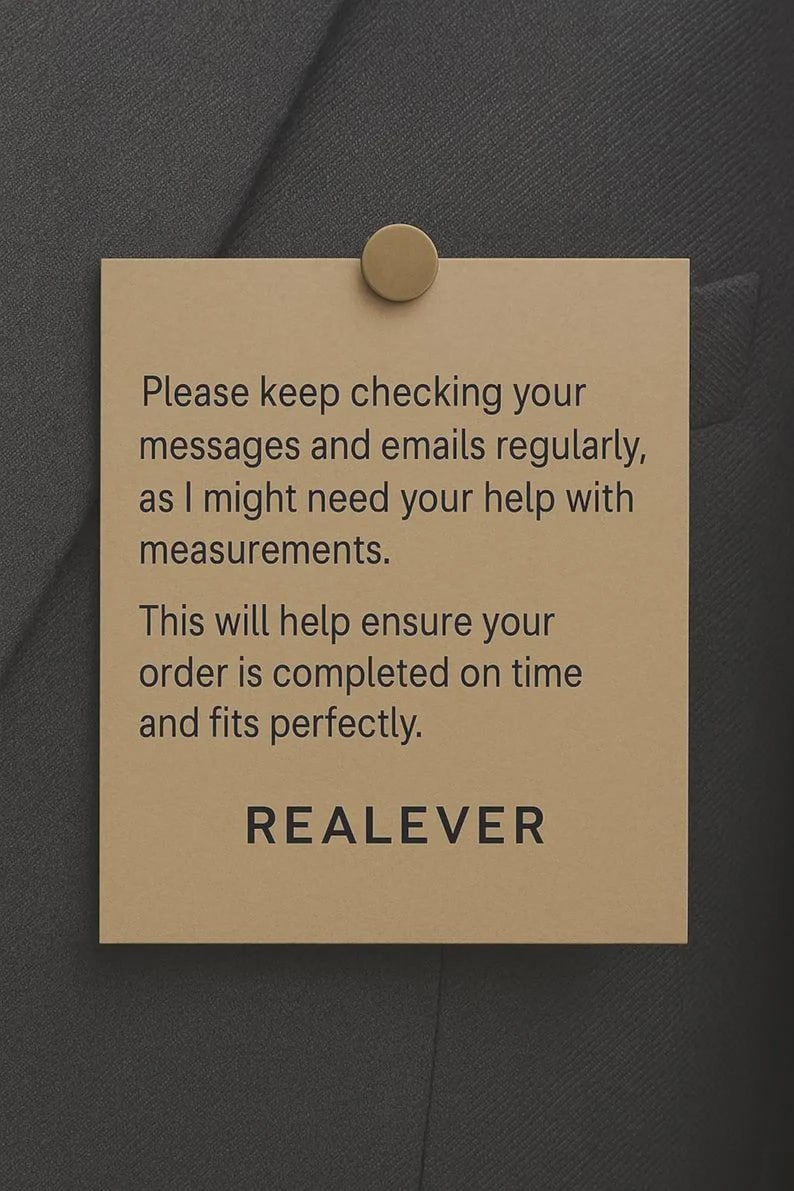 May include: A tan rectangular tag is pinned to a dark gray fabric with a gold-colored tack. The tag has the text: "Please keep checking your messages and emails regularly, as I might need your help with measurements. This will help ensure your order is completed on time and fits perfectly. REALEVER."