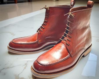May include: A pair of brown leather boots with a classic design. The boots feature a lace-up closure, a rounded toe, and a sturdy sole. The leather has a polished finish, and the boots appear to be new. The boots are approximately 6 inches tall.