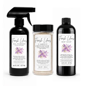 Może przedstawiać: Zestaw trzech produktów czyszczących Kinfolk Candle Co. z etykietą Fresh Lilacs: czarna butelka z rozpylaczem 473 ml uniwersalnego środka czyszczącego, przezroczysty słoik 454 g odświeżacza do dywanów i czarna butelka 473 ml mydła do podłóg.