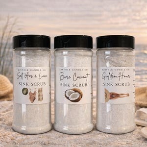 May include: A white ceramic mug with a black handle and the text "But First, Coffee" in a bold, black font. The mug is set against a neutral background, highlighting its simple design.