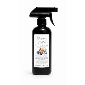 Puede incluir: Una botella de spray de plástico negro que contiene 473 ml de limpiador multiusos. La etiqueta blanca presenta el texto Blueberry Muffin All Purpose Cleaner, una ilustración de un muffin con arándanos e instrucciones de uso.