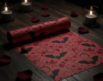 Pode incluir: Papel de embrulho vermelho com um padrão de morcegos e rosas pretas. O papel está parcialmente desenrolado, revelando o padrão repetido. A cena inclui velas acesas e pétalas de rosa, criando um tema gótico ou de Halloween.