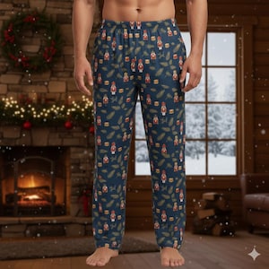 May include: Navy blue pajama pants with a repeating pattern of red and gold nutcrackers, drums, and sprigs. The pants have an elastic waistband and a relaxed fit, perfect for lounging during the holiday season.