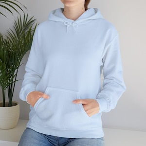 May include: A light blue hoodie with a kangaroo pocket and a drawstring hood. The long-sleeved sweatshirt is made of a soft material. The person is wearing blue jeans.