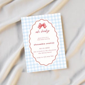 May include: A baby shower invitation with a light blue gingham pattern. The invitation has a red scalloped oval with the words "oh baby" in script. The text reads "please join us for a baby shower honoring Alexandra Conway" and includes event details.