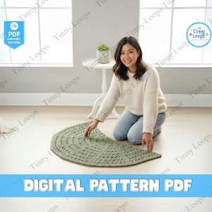 Puede incluir: Una mujer se arrodilla junto a una alfombra de ganchillo verde salvia con forma redondeada. La alfombra está sobre un suelo claro. La imagen incluye el texto "DIGITAL PATTERN PDF" y los logotipos de "Tinny Loops".
