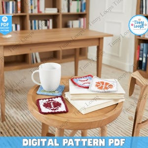 Peut inclure: Une tasse blanche est posée sur un dessous de verre crocheté bleu, avec trois autres dessous de verre crochetés sur le thème du sport à proximité. Un ballon de football américain, un baseball et un design de basket-ball sont visibles. Le texte "DIGITAL PATTERN PDF" est en bas.